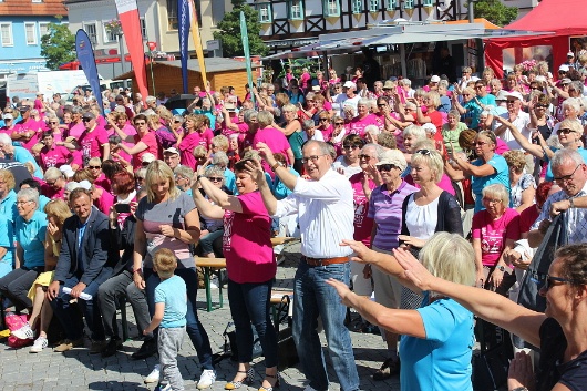 Die Teilnehmer der Eröffnungsveranstaltung machen gemeinsam Gymnastik zur Erwärmung